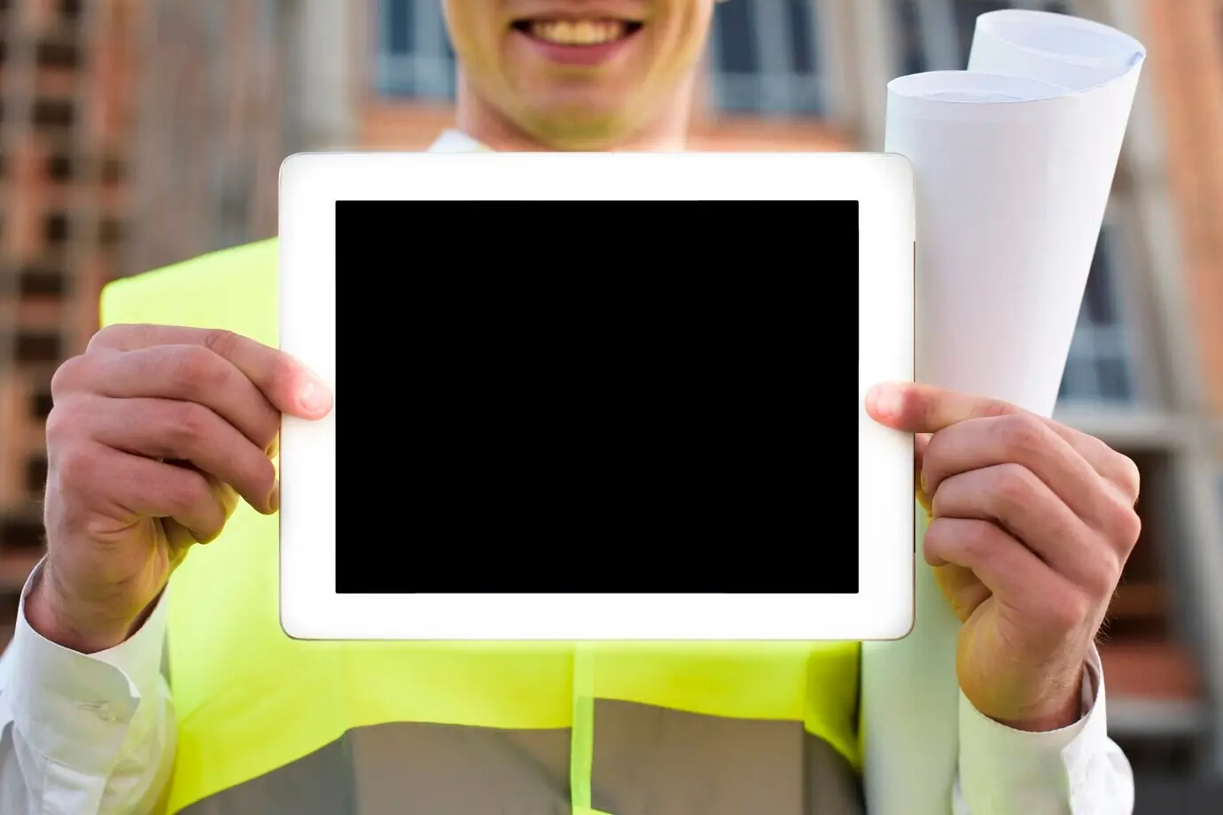 Nahaufnahme eines lächelnden Mannes, der ein Tablet hochhält.